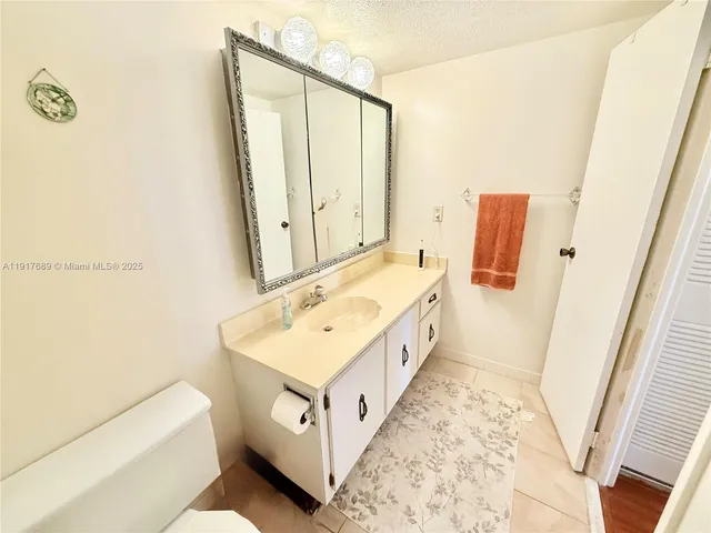 a bathroom with a sink a toilet a mirror and shower