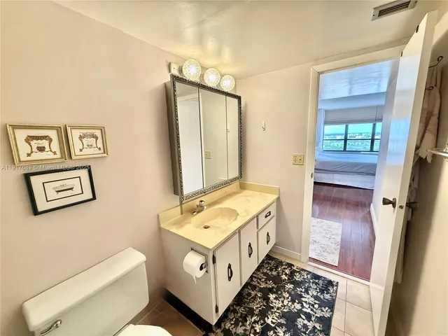 a bedroom with a bed couches chair and a large window