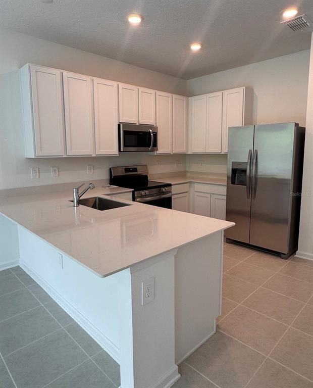 2769 Skyline Loop Kissimmee, FL 34758 - Photo 3 of 17 a kitchen with cabinets stainless steel appliances and a sink