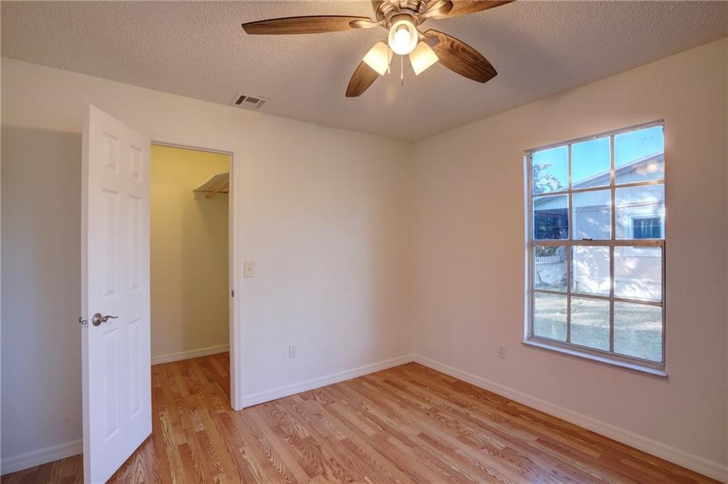 441 Columbus Street Sebastian, FL 32958 - Photo 22 of 35 an empty room with wooden floor chandelier fan and windows