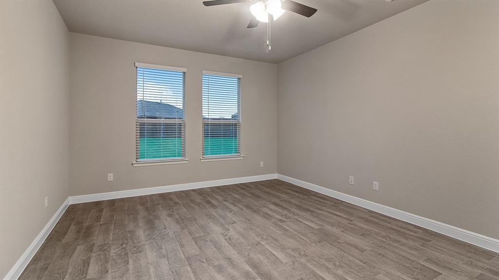 219 Windmill Drive Rhome, TX 76078 - Photo 9 of 29 wooden floor in an empty room with a window