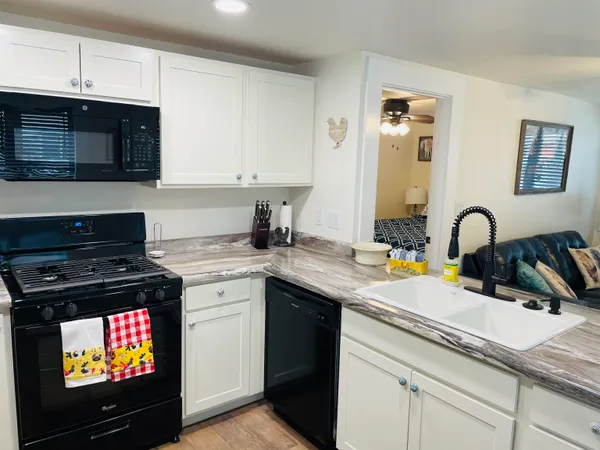 a kitchen with stainless steel appliances granite countertop a stove a sink and a microwave