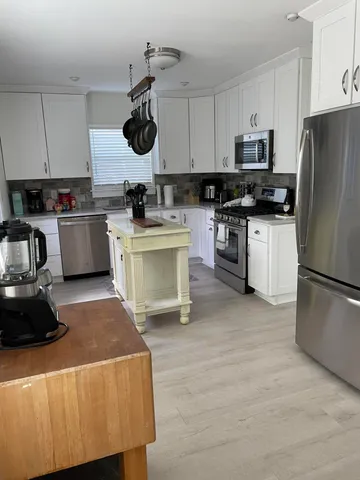a kitchen with a refrigerator and white cabinets