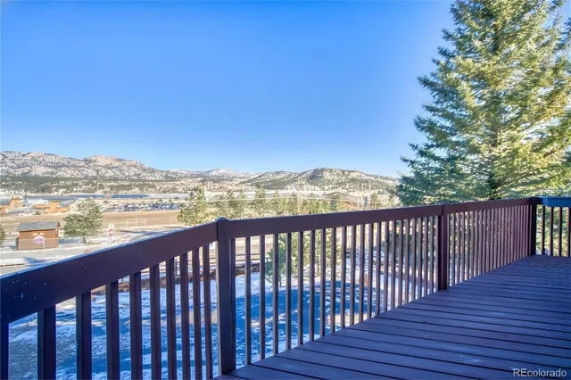 a balcony with wooden floor and city view