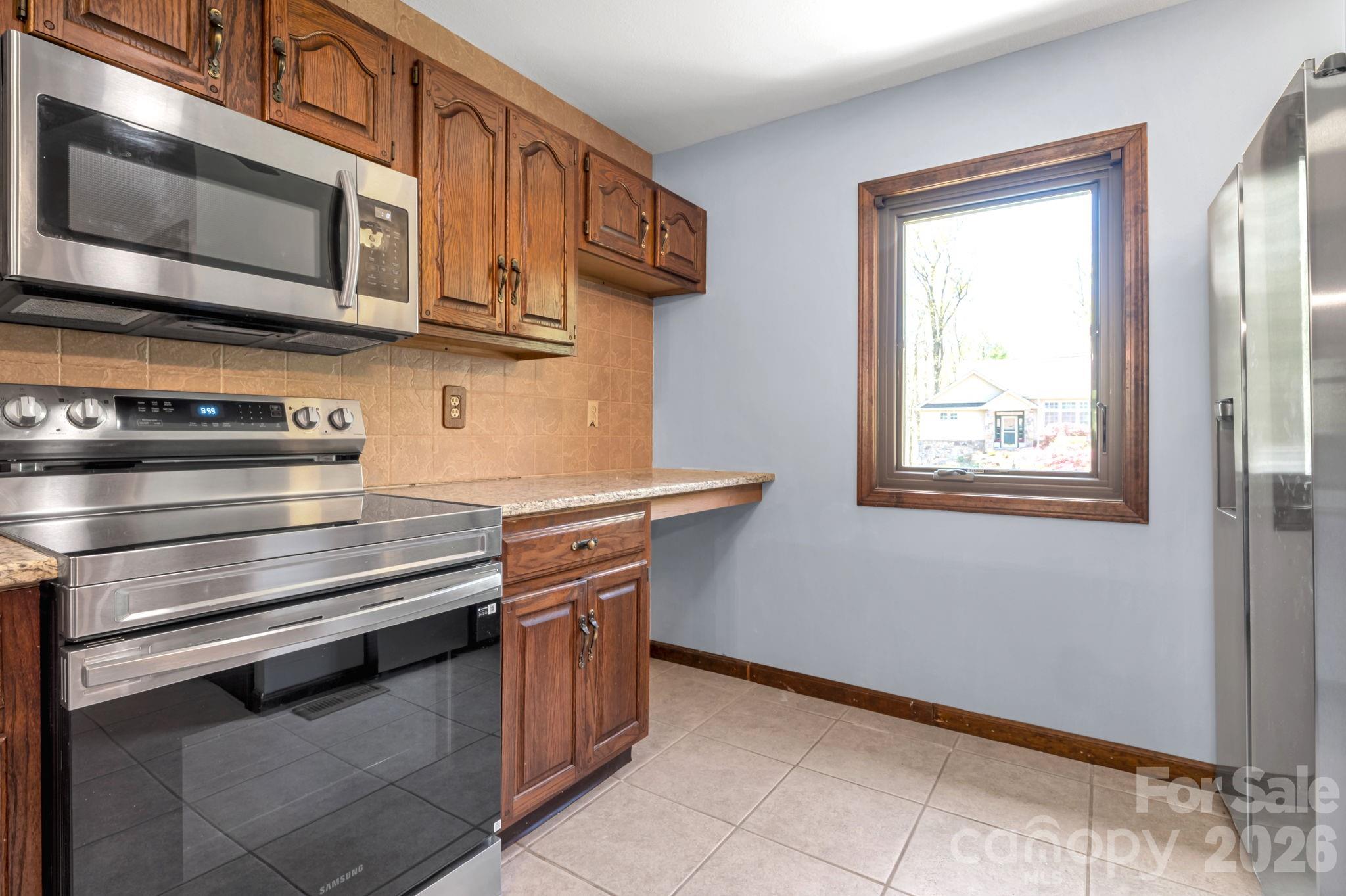 3104 Cove Loop Road Hendersonville, NC 28739 - Photo 18 of 40 a kitchen with stainless steel appliances granite countertop a stove and a microwave