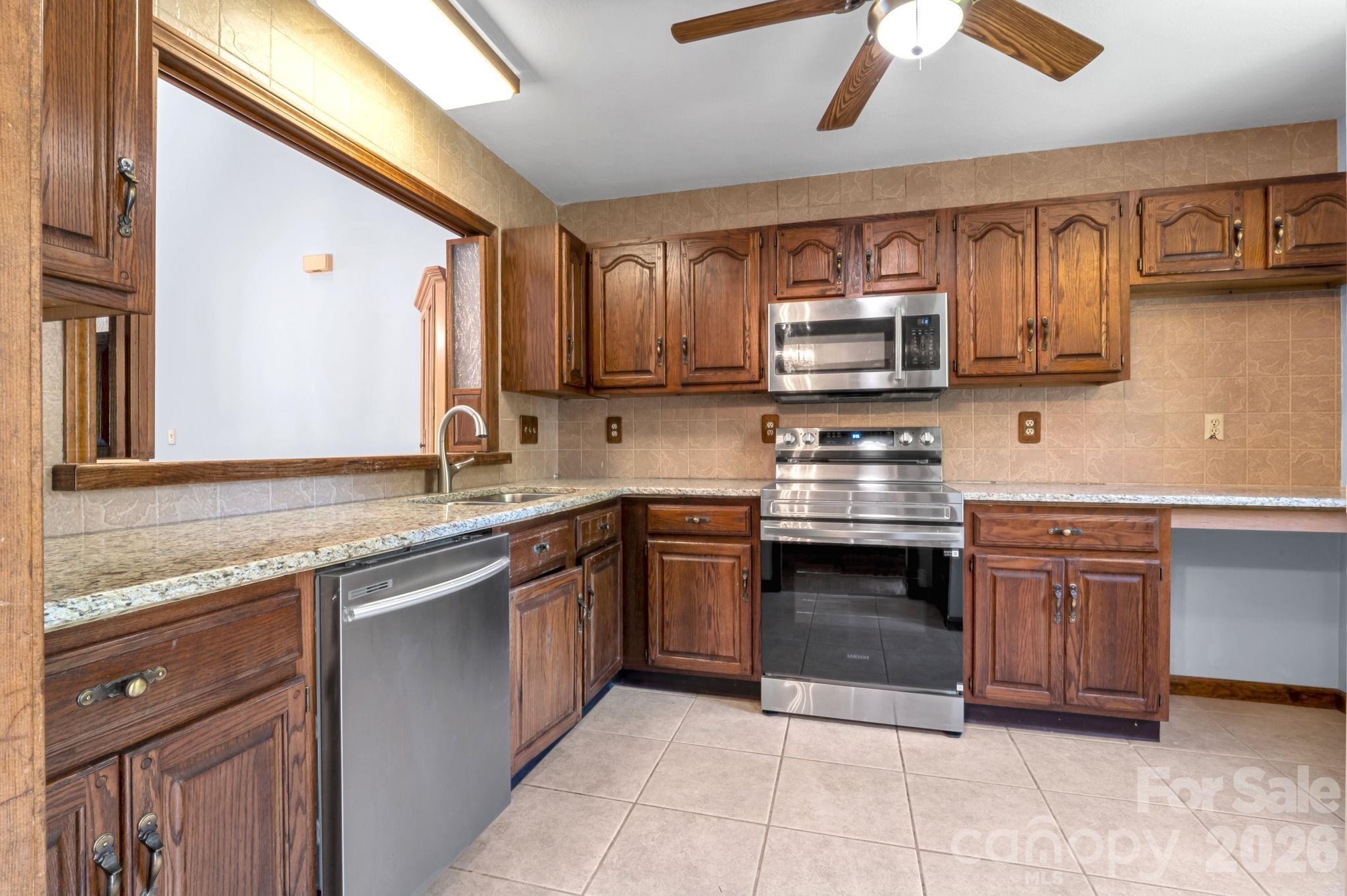 3104 Cove Loop Road Hendersonville, NC 28739 - Photo 19 of 40 a kitchen with stainless steel appliances granite countertop a stove sink and cabinets