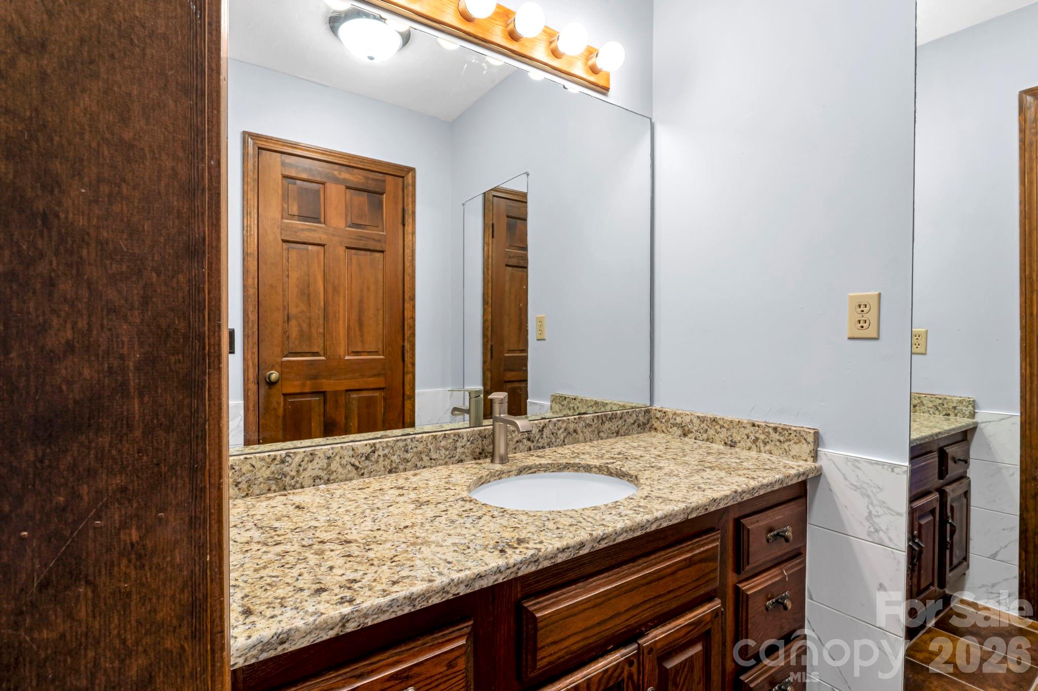 3104 Cove Loop Road Hendersonville, NC 28739 - Photo 22 of 40 a bathroom with a granite countertop sink and a mirror