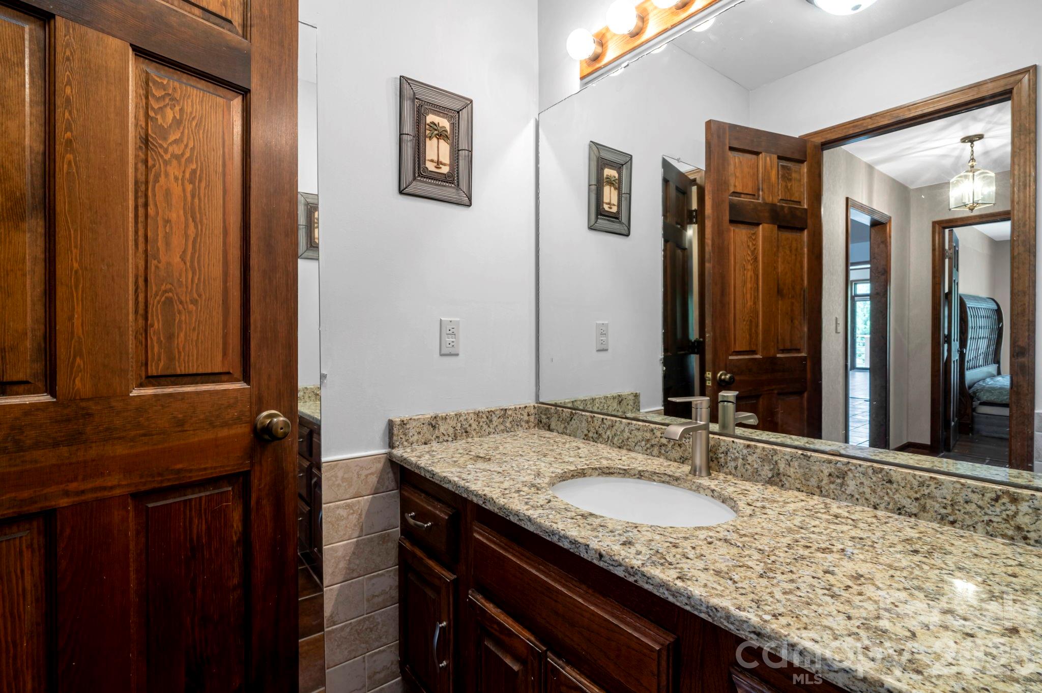 3104 Cove Loop Road Hendersonville, NC 28739 - Photo 26 of 40 a bathroom with a granite countertop sink and a mirror