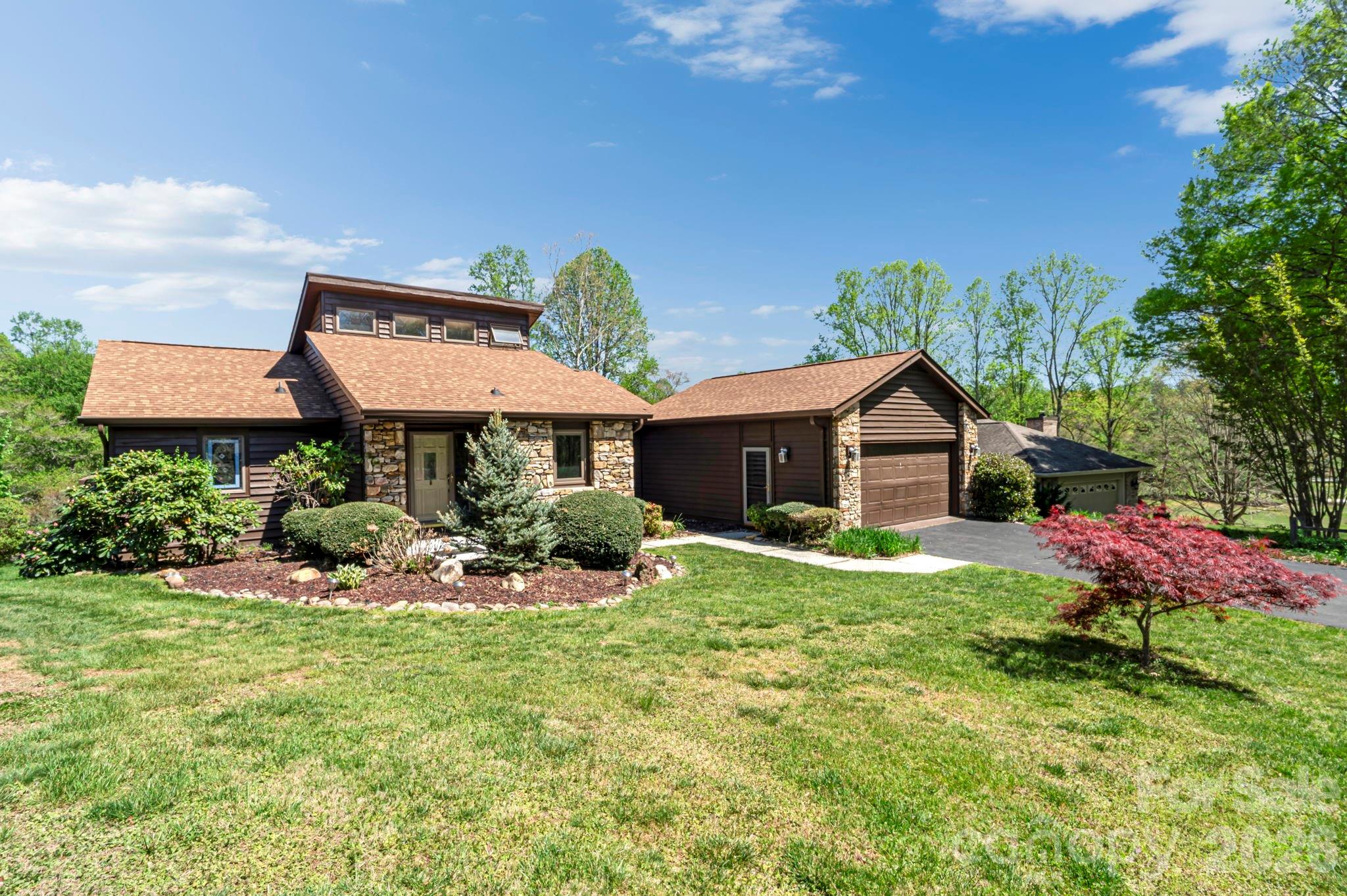 3104 Cove Loop Road Hendersonville, NC 28739 - Photo 4 of 40 a front view of a house with a yard and garage
