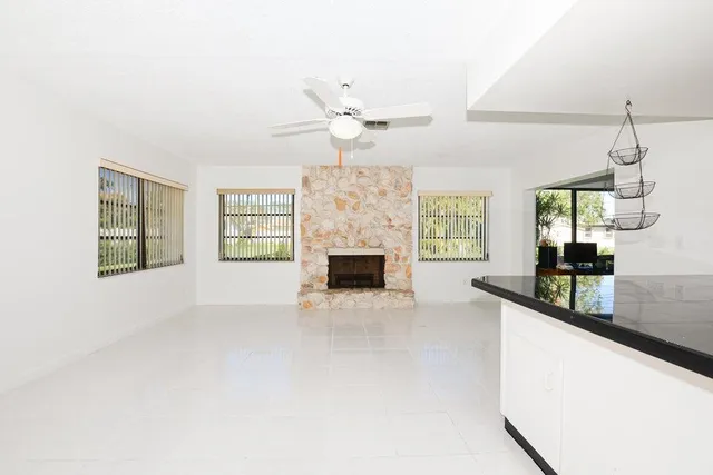 a view of an empty room with a fireplace and a window
