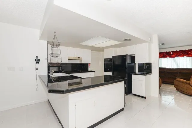 a kitchen with stainless steel appliances granite countertop a refrigerator and a stove