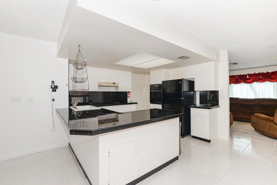 1117 Southeast Mendoza Avenue Port St. Lucie, FL 34952 - Photo 12 of 24 a kitchen with stainless steel appliances granite countertop a refrigerator and a stove