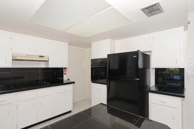 a kitchen with stainless steel appliances a refrigerator and cabinets