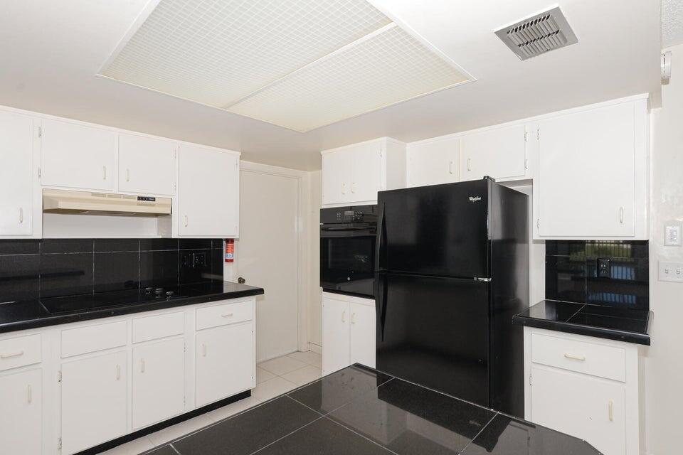 1117 Southeast Mendoza Avenue Port St. Lucie, FL 34952 - Photo 13 of 24 a kitchen with stainless steel appliances a refrigerator and cabinets