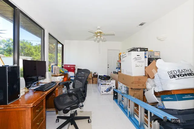 a view of a workspace with furniture and a window