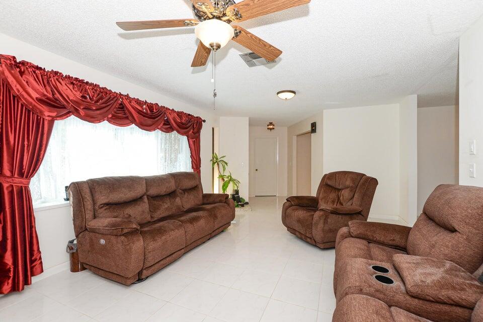 1117 Southeast Mendoza Avenue Port St. Lucie, FL 34952 - Photo 6 of 24 a living room with furniture a couch and a chandelier