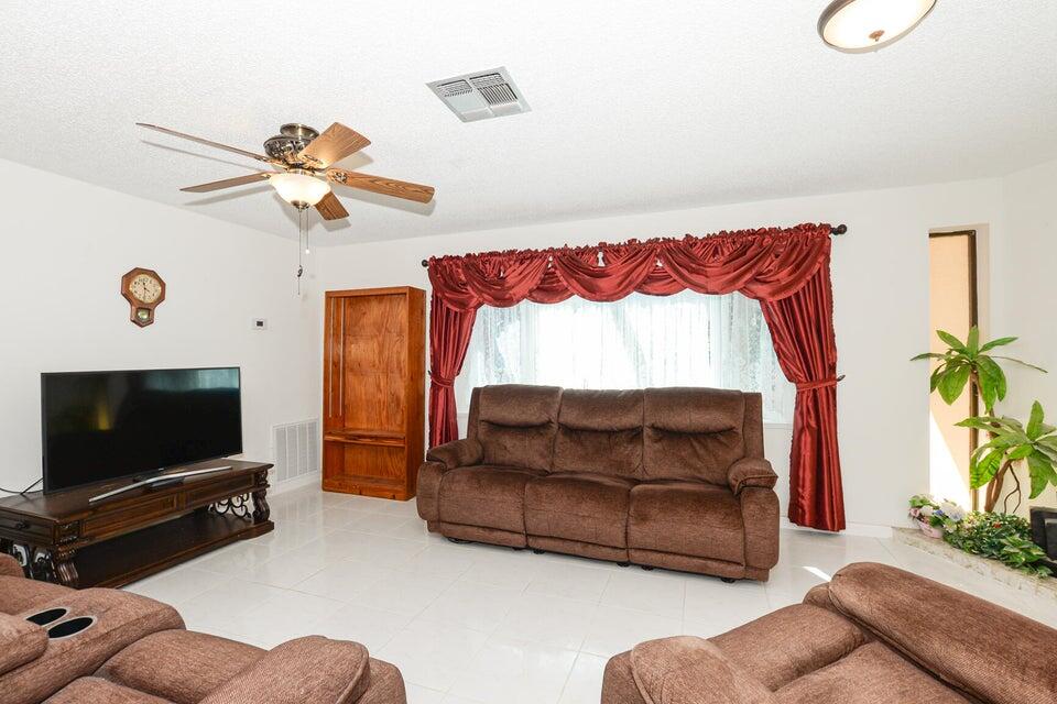 1117 Southeast Mendoza Avenue Port St. Lucie, FL 34952 - Photo 7 of 24 a living room with furniture and a flat screen tv