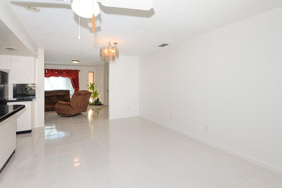 1117 Southeast Mendoza Avenue Port St. Lucie, FL 34952 - Photo 9 of 24 a living room with furniture and a chandelier