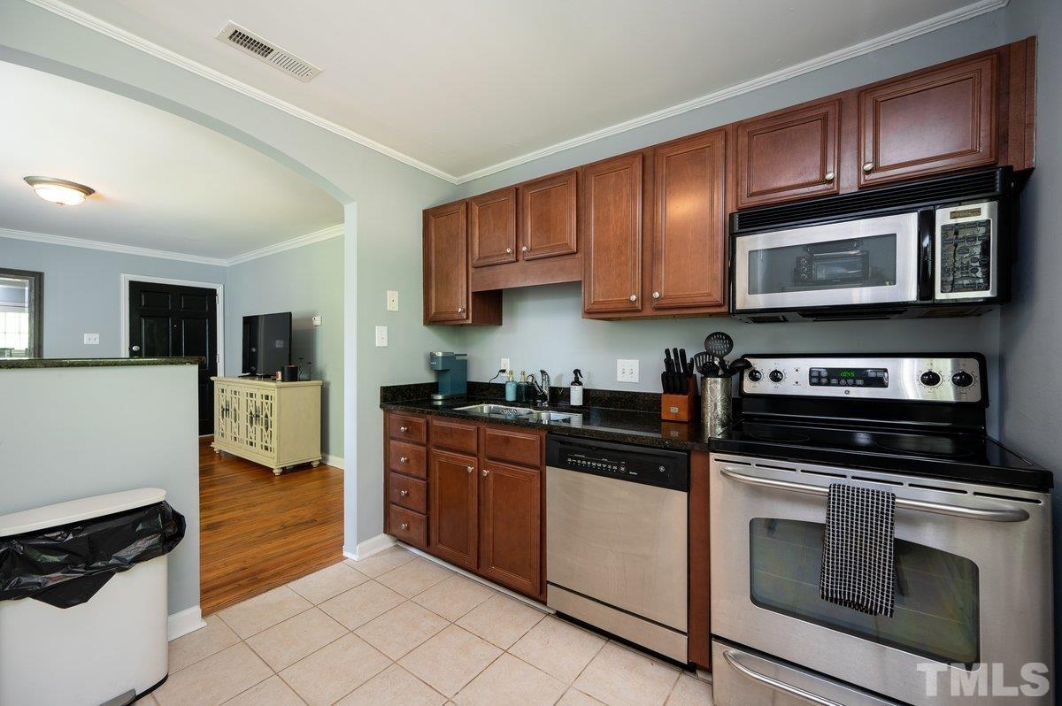 2215 Bernard Street, Unit 2215 Raleigh, NC 27608 - Photo 8 of 16 a kitchen with stainless steel appliances granite countertop a stove microwave and cabinets