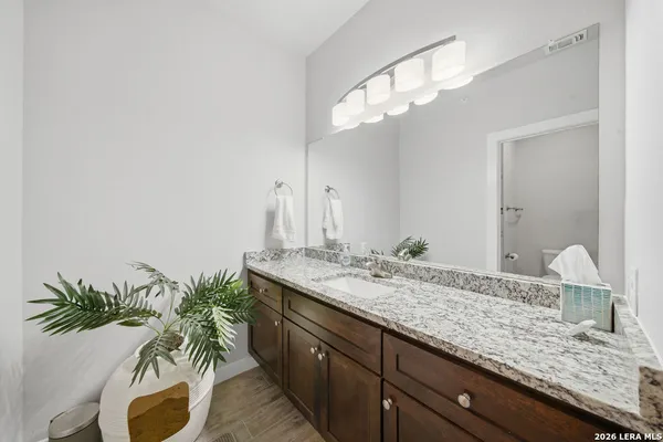 a bathroom with a granite countertop sink and a mirror