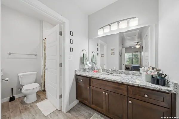 a spacious bathroom with a granite countertop sink toilet a large mirror a and shower
