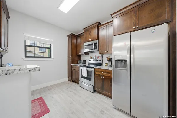 a kitchen with stainless steel appliances granite countertop a refrigerator a stove a sink and a microwave