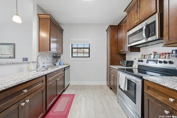 a kitchen with stainless steel appliances granite countertop a sink and stove top oven