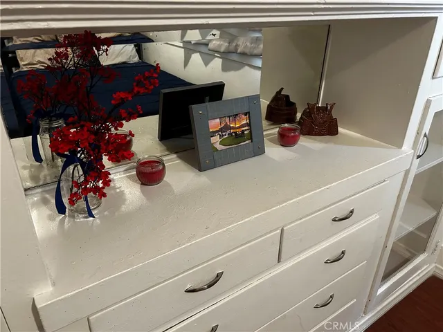 a bed sitting in a bedroom next to a lamp with chair and a potted plant