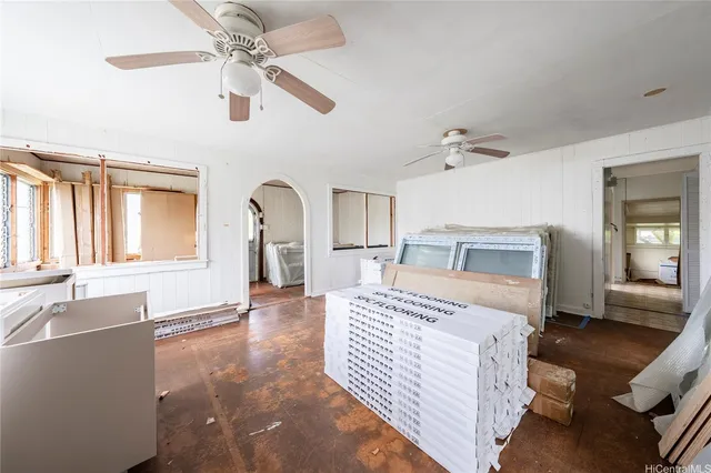 a bedroom with a large bed and a chandelier fan