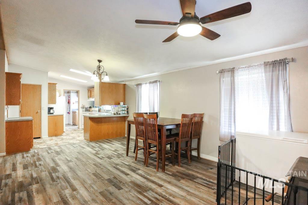 815 Eaton Road Weiser, ID 83672 - Photo 13 of 50 Dining area featuring light wood-type flooring, a chandelier, a ceiling fan, and lofted ceiling