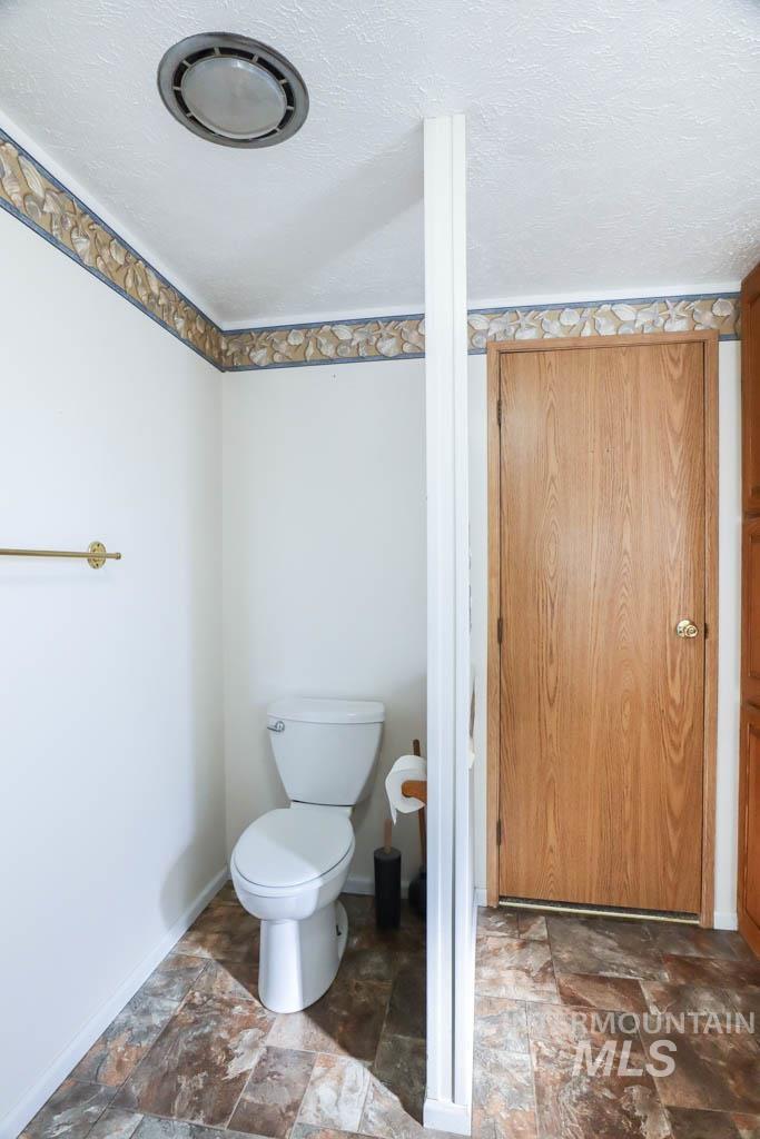 815 Eaton Road Weiser, ID 83672 - Photo 23 of 50 Bathroom with stone finish floors and a textured ceiling