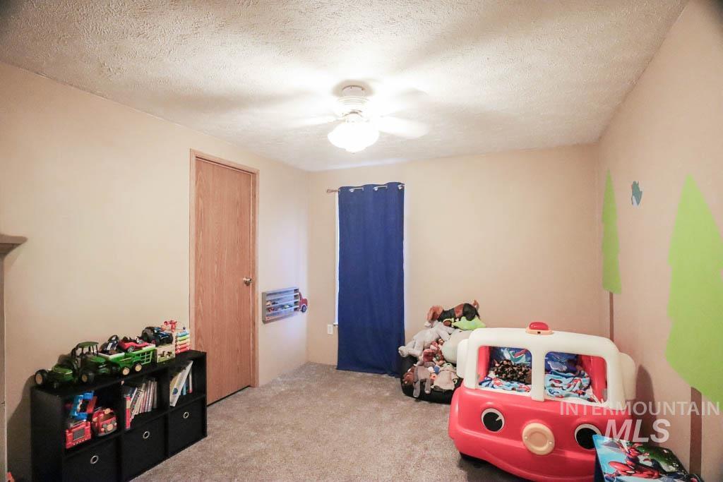815 Eaton Road Weiser, ID 83672 - Photo 28 of 50 Bedroom featuring light colored carpet, a textured ceiling, and ceiling fan
