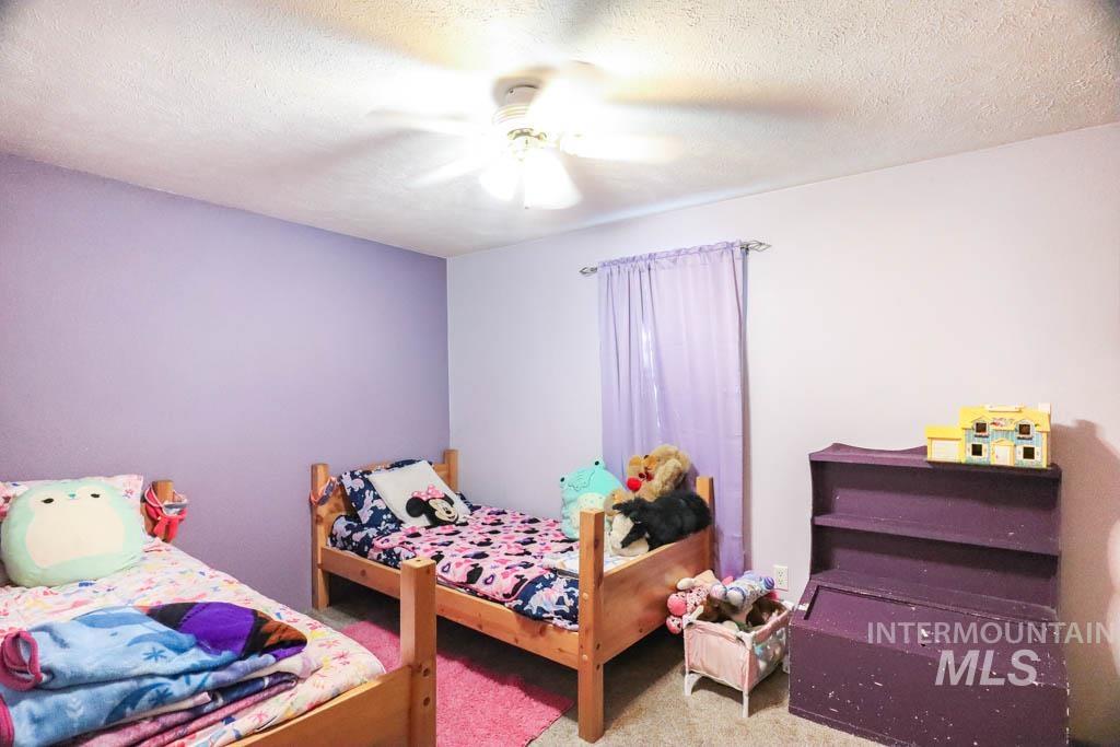 815 Eaton Road Weiser, ID 83672 - Photo 29 of 50 Bedroom with a textured ceiling, carpet floors, and a ceiling fan