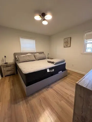 a bedroom with a bed and wooden floor