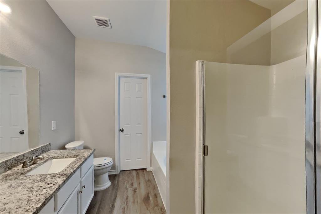105 Independence Trail Forney, TX 75126 - Photo 11 of 18 a spacious bathroom with a granite countertop sink a mirror and a bathtub