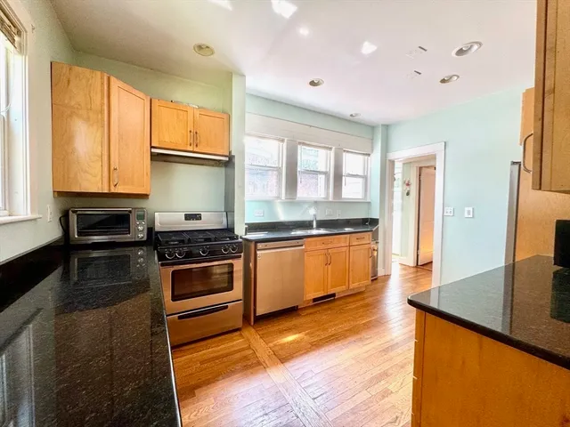 a kitchen with stainless steel appliances granite countertop a stove a sink and a refrigerator