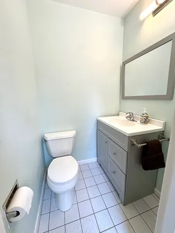 a bathroom with a toilet sink vanity and mirror