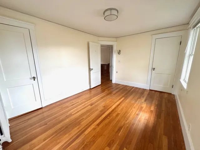 a view of a room with wooden floor and white walls