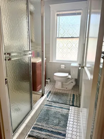 a bathroom with a toilet and a shower