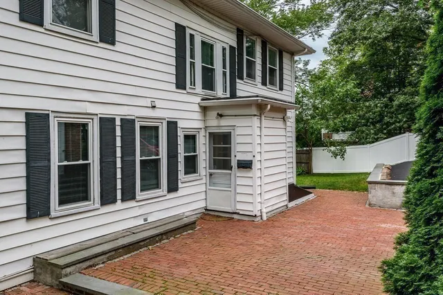 a view of a house with a yard and wooden fence