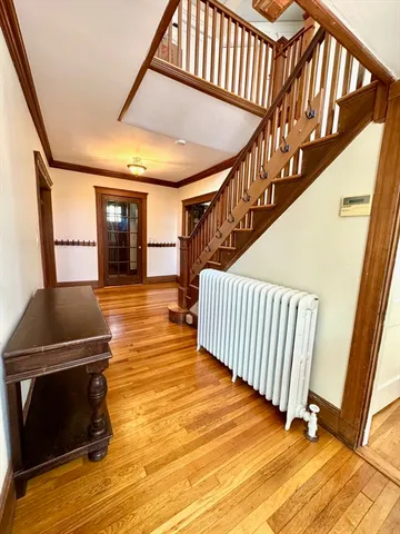 a view of entryway and hall with wooden floor