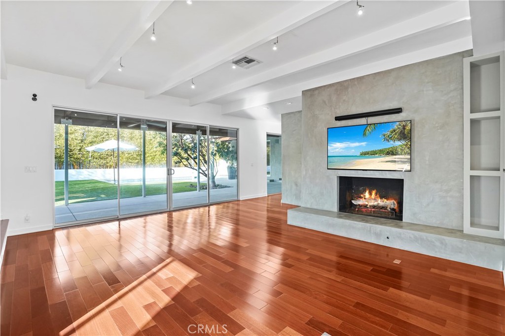 16301 Meadow Ridge Road West Encino, CA 91436 - Photo 12 of 33 a view of an empty room with wooden floor fireplace and a window