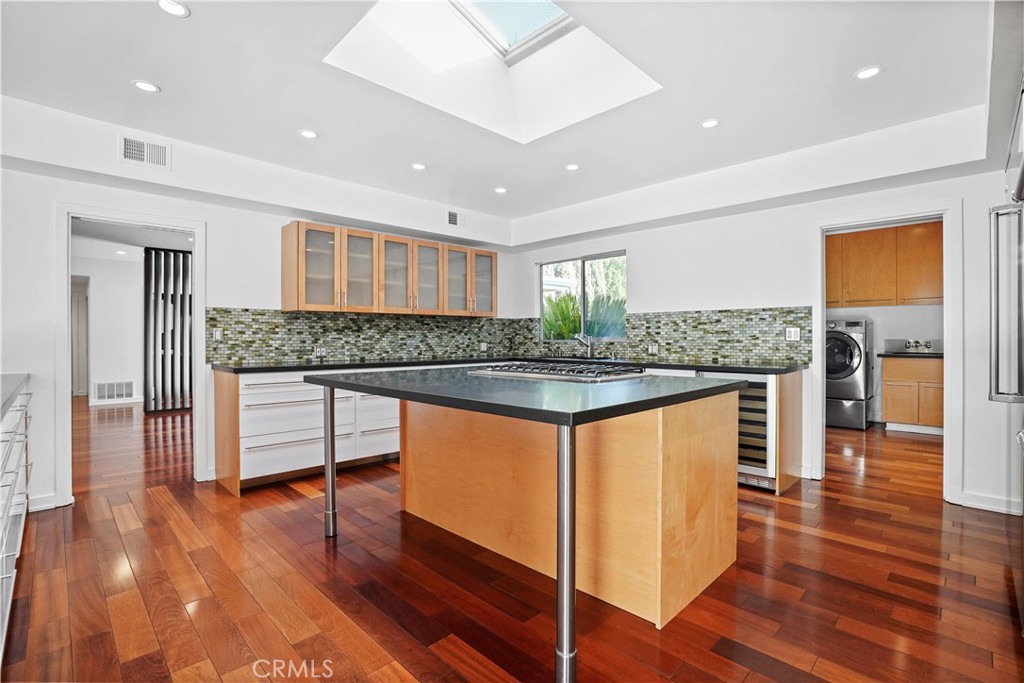 16301 Meadow Ridge Road West Encino, CA 91436 - Photo 17 of 33 a kitchen with granite countertop wooden floors and white cabinets