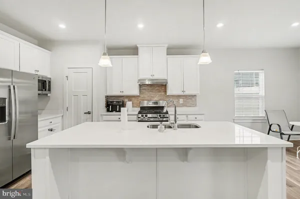 a kitchen with kitchen island stainless steel appliances a sink and cabinets