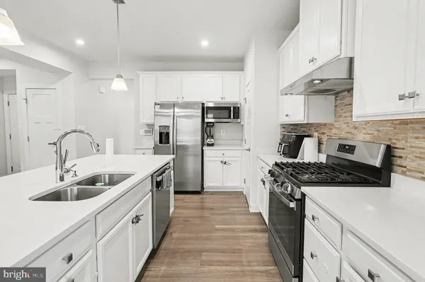 a kitchen with a sink stove top oven and refrigerator