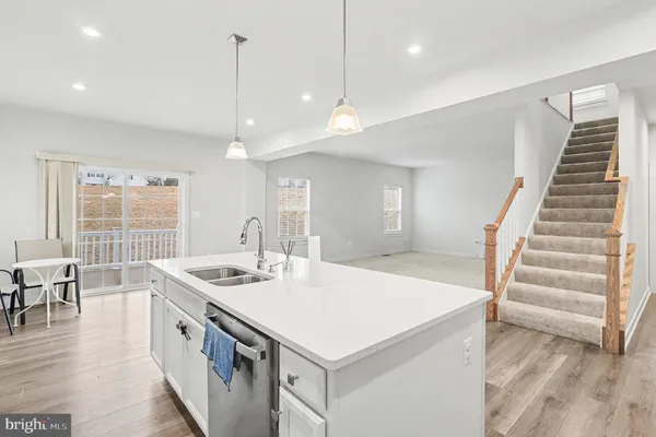 a kitchen that has a sink a center island and wooden floor