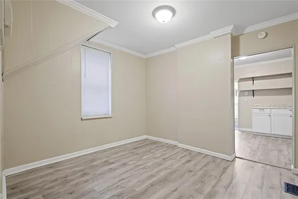 a view of empty room with wooden floor