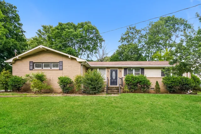 a view of a house with yard and a garden