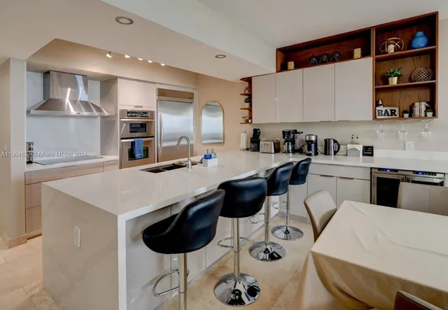 a kitchen with a sink a refrigerator and cabinets