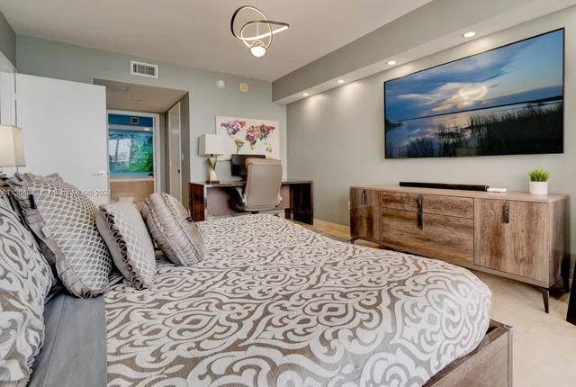 a bedroom with a bed and a flat screen tv